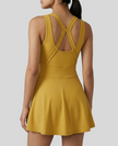CourtFlow Active Dress in mustard with crossback and wide straps, studio back view