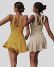 Two women wearing yellow and beige tennis dresses against a plain background