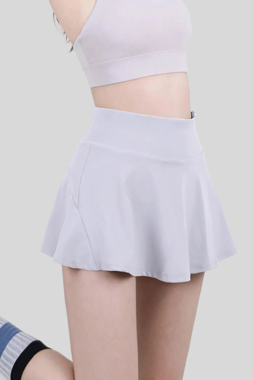 White athletic skort with a flowy skirt overlay and built-in compression shorts - Athlesi