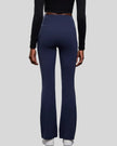 Back view of EarthFlow Studio Flare Pant in dark blue with clean, seamless waistband
