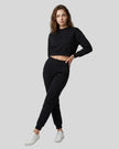 Model wearing black Athlesi EaseForm cropped sweatshirt and jogger set