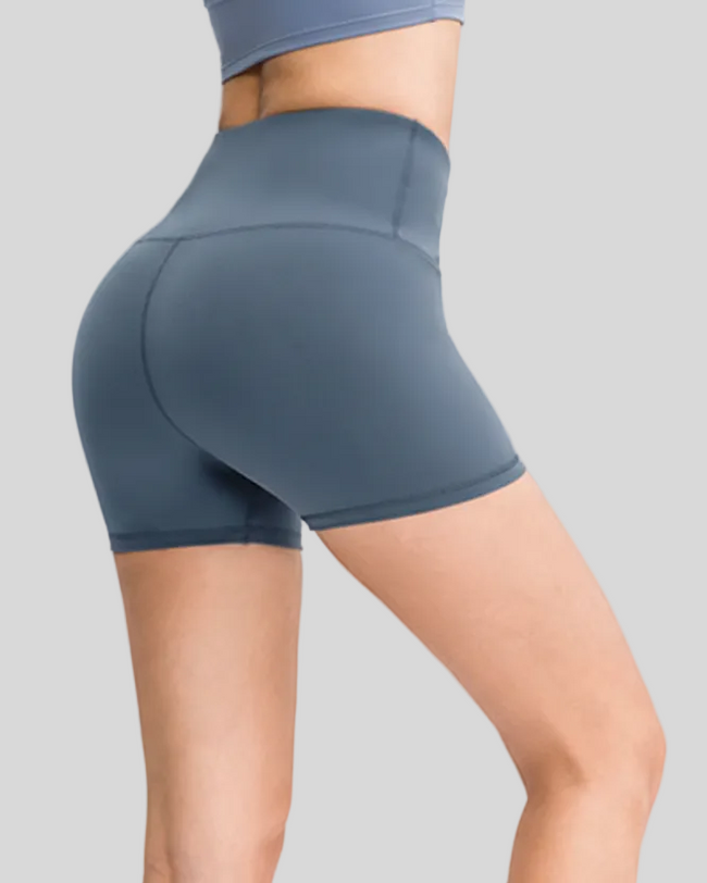 Dusty blue high-waisted activewear shorts on a gray background