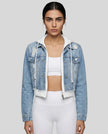 Woman wearing a dark blue and white Athlesi EdgeForm denim hoodie jacket with white leggings, mid body front view on model showing cropped fit and layered hoodie 