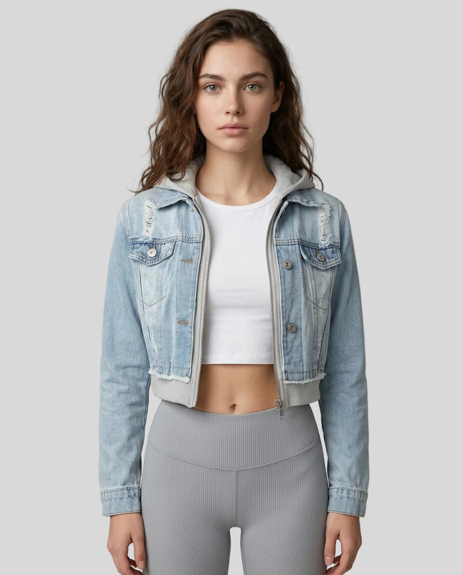 Woman wearing a light blue and gray Athlesi EdgeForm denim hoodie jacket with gray leggings, mid body front view on model showing cropped fit and layered hoodie 
