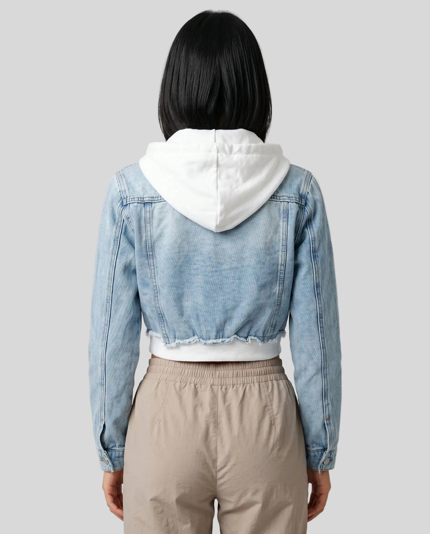Back view of model wearing Athlesi EdgeForm light blue denim jacket over a white crop top and beige pants
