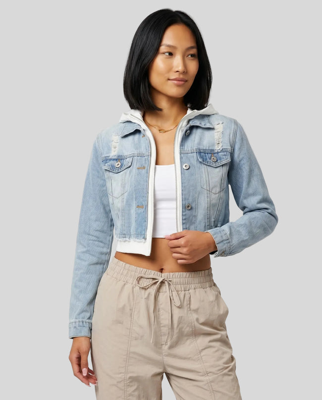 Front angle view of model wearing Athlesi EdgeForm light blue denim jacket over a white crop top and beige pants