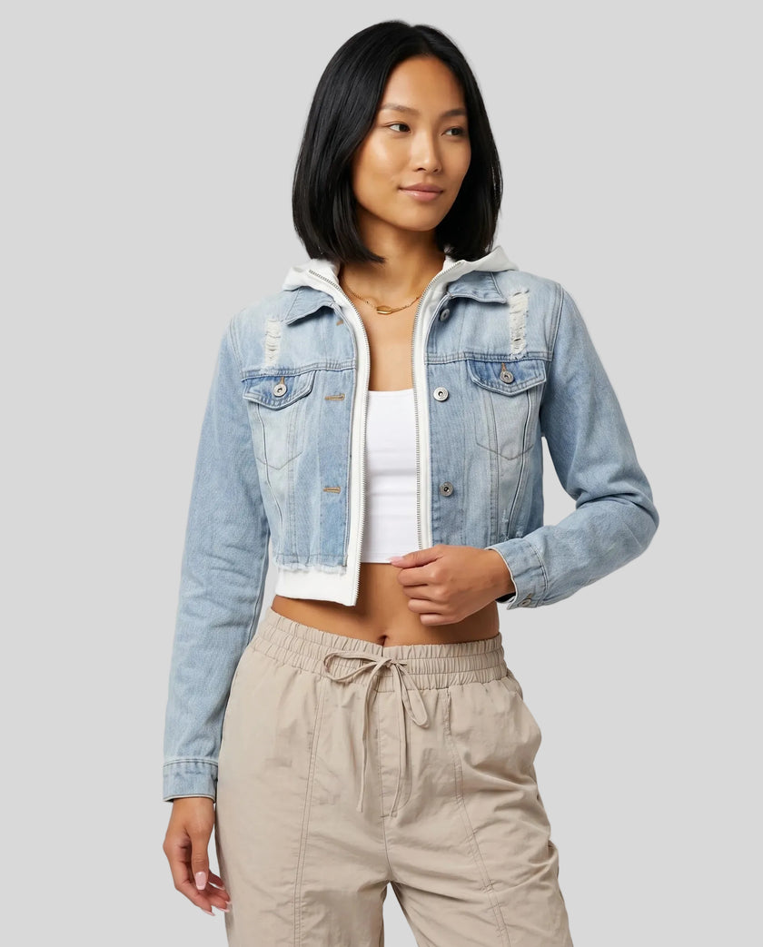 Front angle view of model wearing Athlesi EdgeForm light blue denim jacket over a white crop top and beige pants