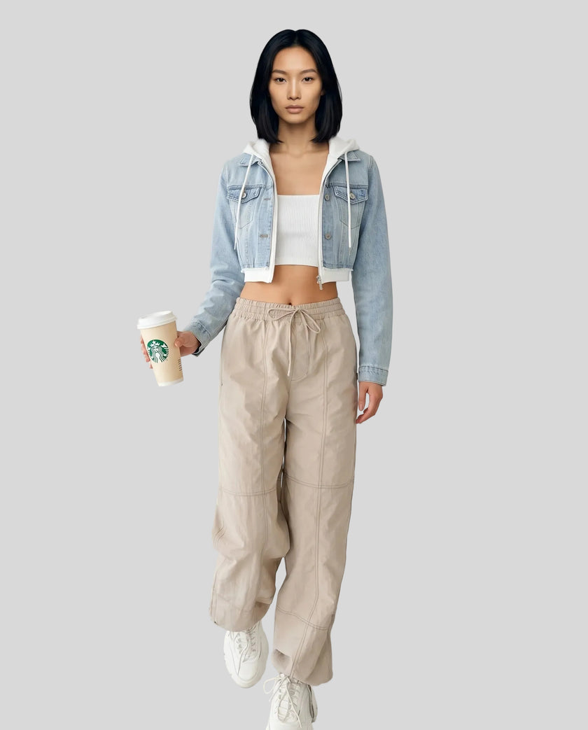 Front full body view of model wearing Athlesi EdgeForm light blue denim jacket over a white crop top and beige pants