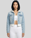 Woman wearing a light blue and white Athlesi EdgeForm denim hoodie jacket with white leggings, mid body front view on model showing cropped fit and layered hoodie 