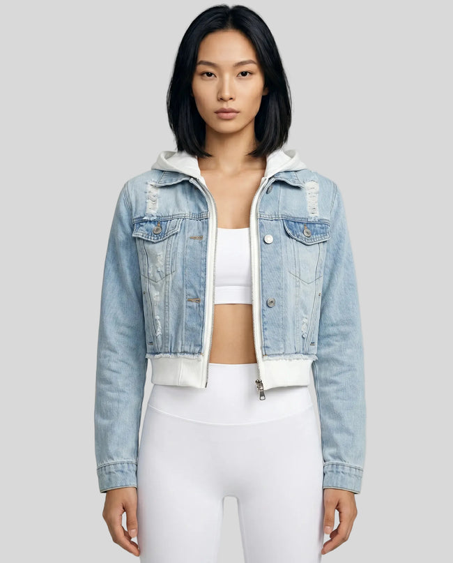 Woman wearing a light blue and white Athlesi EdgeForm denim hoodie jacket with white leggings, mid body front view on model showing cropped fit and layered hoodie 