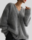 Person wearing a dark gray sweater with a blurred background