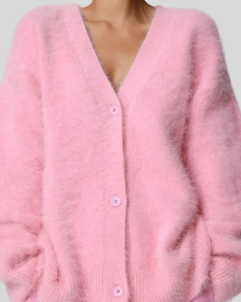 Pink cardigan worn by a person on a light gray background