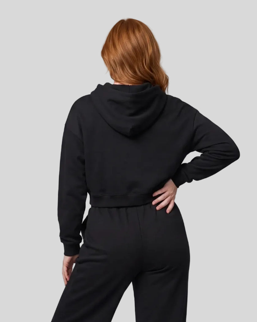Back view of a model wearing the Everyday Cropped Zip-Up Hoodie in Black