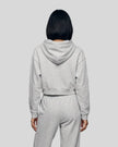Back view of a model wearing the Everyday Cropped Zip-Up Hoodie in Flower Gray