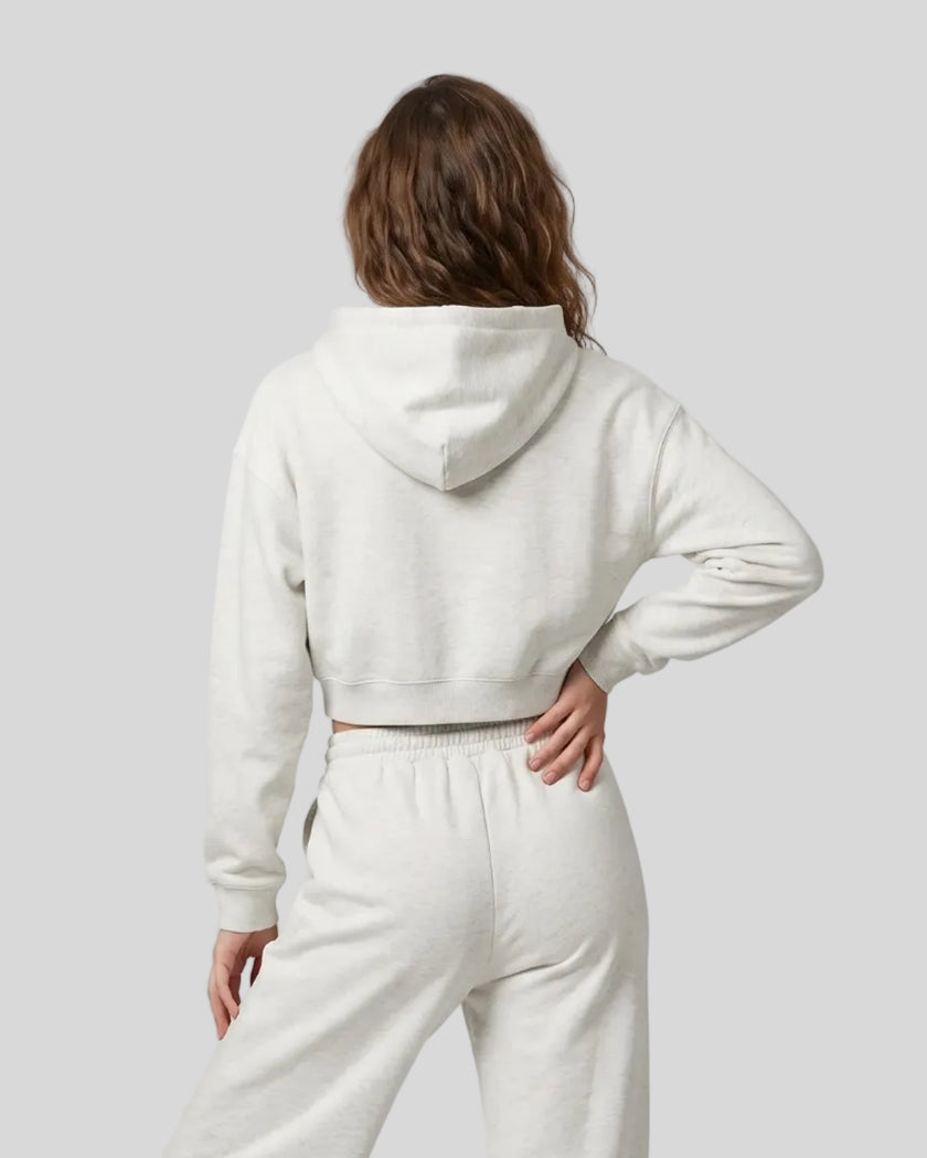 Back view of a model wearing the Everyday Cropped Zip-Up Hoodie in Oat Gray