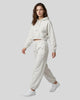 A woman modeling an Oat Gray Everyday Cropped Hoodie and matching Everyday Jogger Pants set with white sneakers.