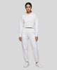 A woman modeling a white Everyday Cropped Hoodie and matching Everyday Jogger Pants set with white sneakers.