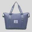 ExpandForm Weekender Bag in dusty blue front view with structured silhouette and dual handles