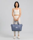Model carrying ExpandForm Weekender Bag in dusty blue styled for studio sessions and everyday movements