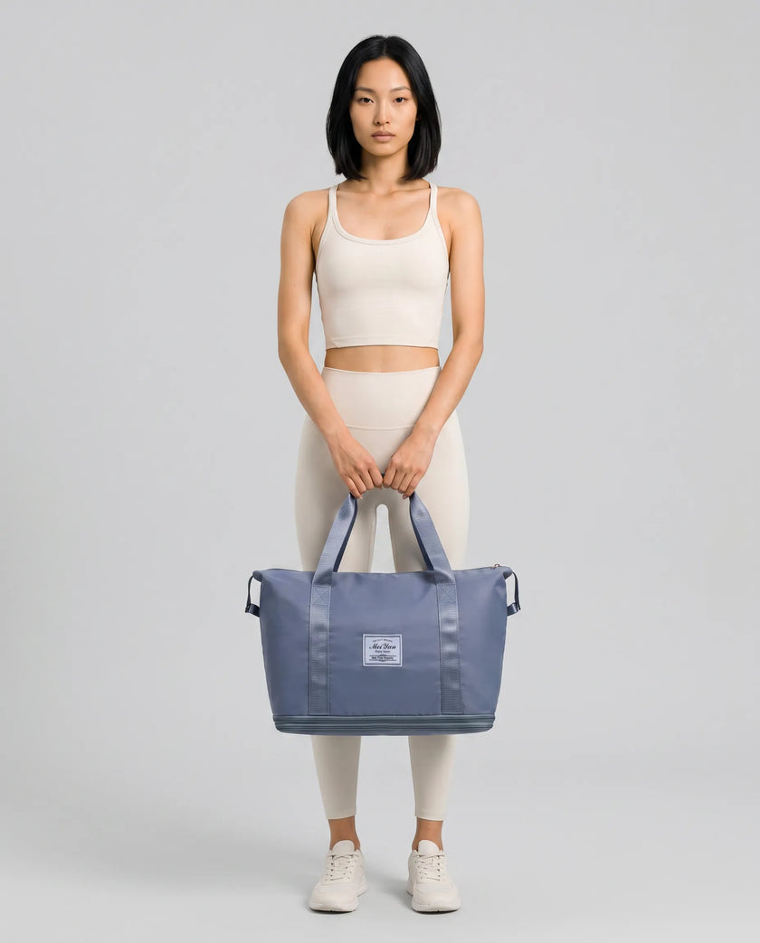 Model carrying ExpandForm Weekender Bag in dusty blue styled for studio sessions and everyday movements