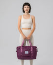 Model carrying ExpandForm Weekender Bag in plum purple styled for studio sessions and everyday movements