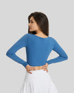 Back view of blue FlowCut Studio Top with smooth fitted silhouette