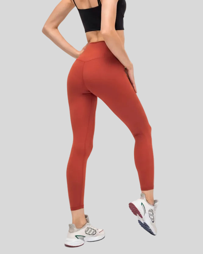 Back angle view of brick red FlowEase High-Waist Pocket Legging with seamless silhouette