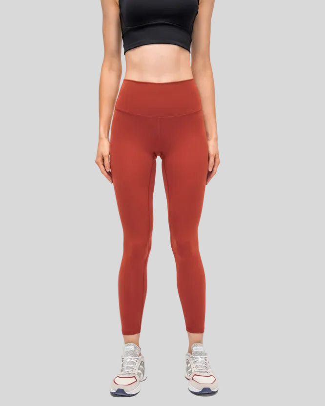 Front view of FlowEase High-Waist Pocket Legging in brick red with clean matte finish