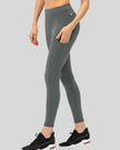 Left side view of dark gray Athlesi FlowForm Utility Legging emphasizing pocket placement and slim fit