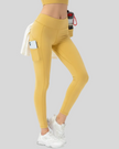Gold flowform utility leggings worn by a woman on a gray background