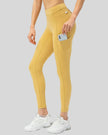 Left side view of gold Athlesi FlowForm Utility Legging emphasizing pocket placement and slim fit