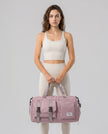 Model holding a dusty pink FlowHold Carry Bag in front with both hands styled for everyday movement