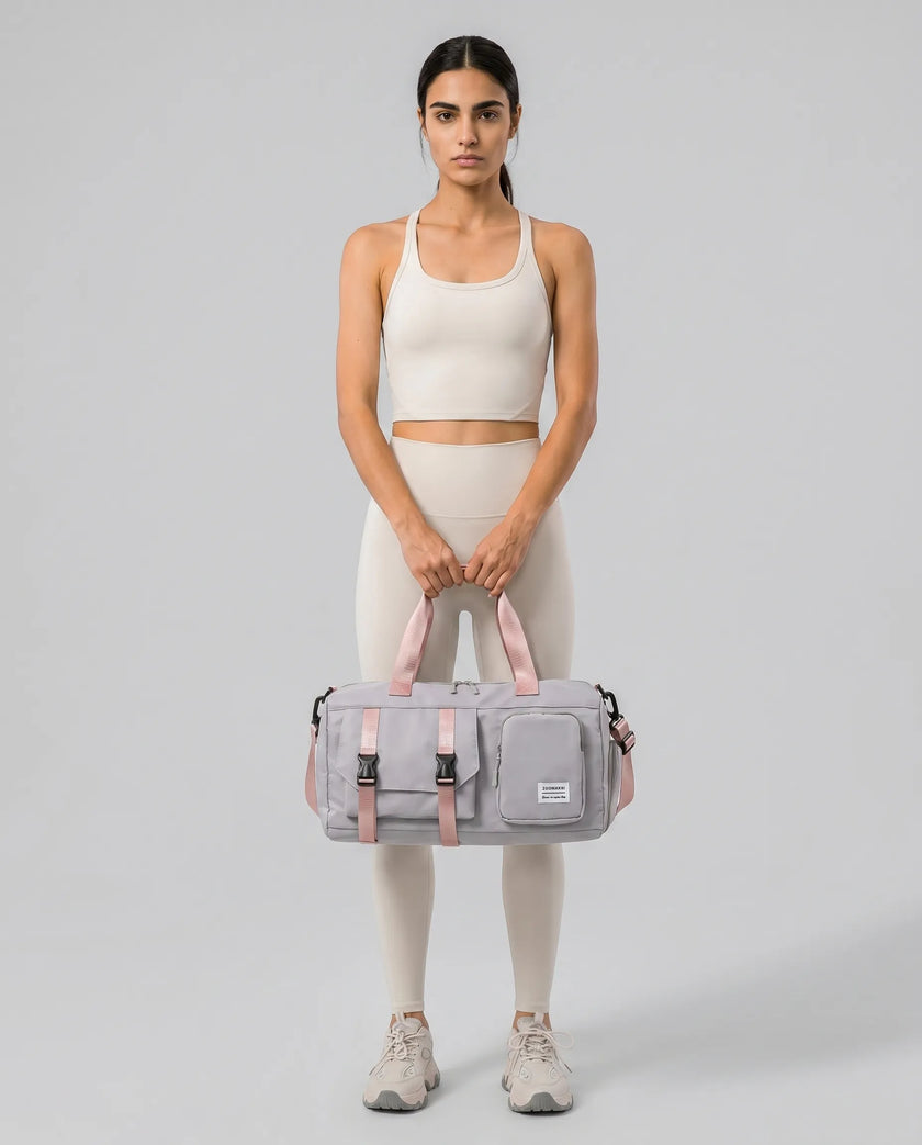 Model holding a gray FlowHold Carry Bag in front with both hands styled for everyday movement