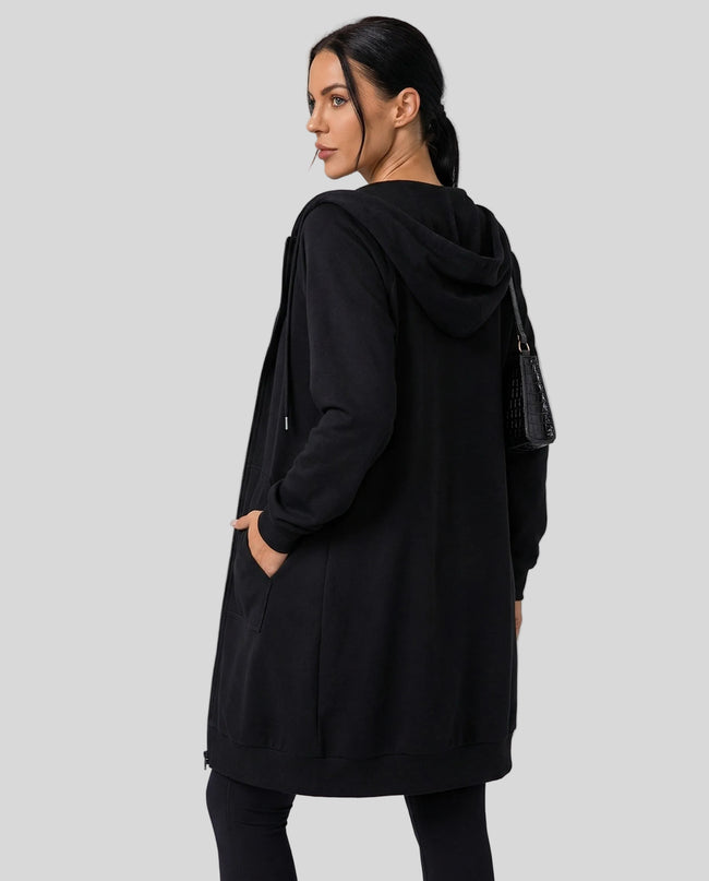 Back view of model wearing longline hoodie showing extended silhouette and clean structure
