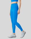 Left side view of blue FlowLine Core Legging with smooth silhouette