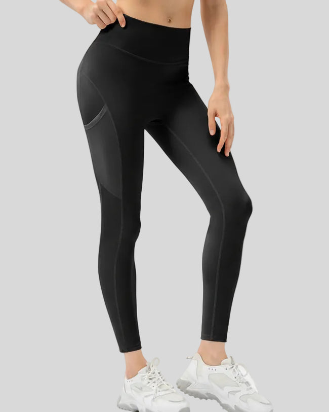 Front view of Athlesi FlowMotion Trail Pocket Legging in black with visible seam detailing