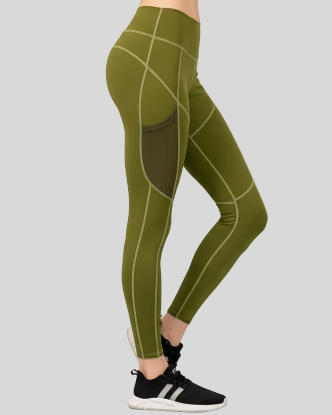 Side view of green FlowMotion Trail Pocket legging with white geometric patterns worn by a woman on a gray background