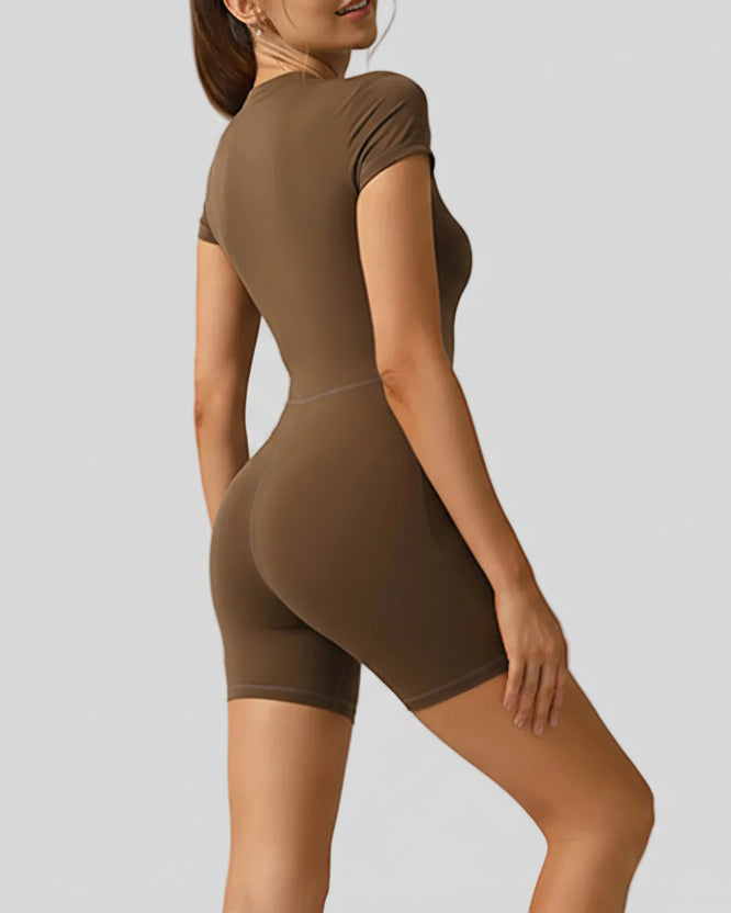 Side view of FlowZip short-sleeve romper in brown showing minimal, sculpted silhouette