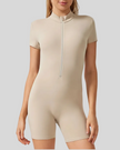 Beige short-sleeve bodysuit with a front zipper on a plain background
