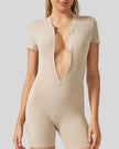 Close-up of FlowZip romper in tan showing half-zip detail and smooth performance fabric