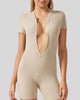 Close-up of FlowZip romper in tan showing half-zip detail and smooth performance fabric
