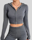 Front upper body view of dark gray Athlesi FormFlare zip hoodie set showing fitted waist and zip detail
