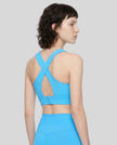 Angled back view of the FormLine Twist Sports Bra styled with coordinating activewear pieces