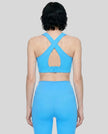 Back view of the FormLine Twist Sports Bra in blue, highlighting the cross-back design