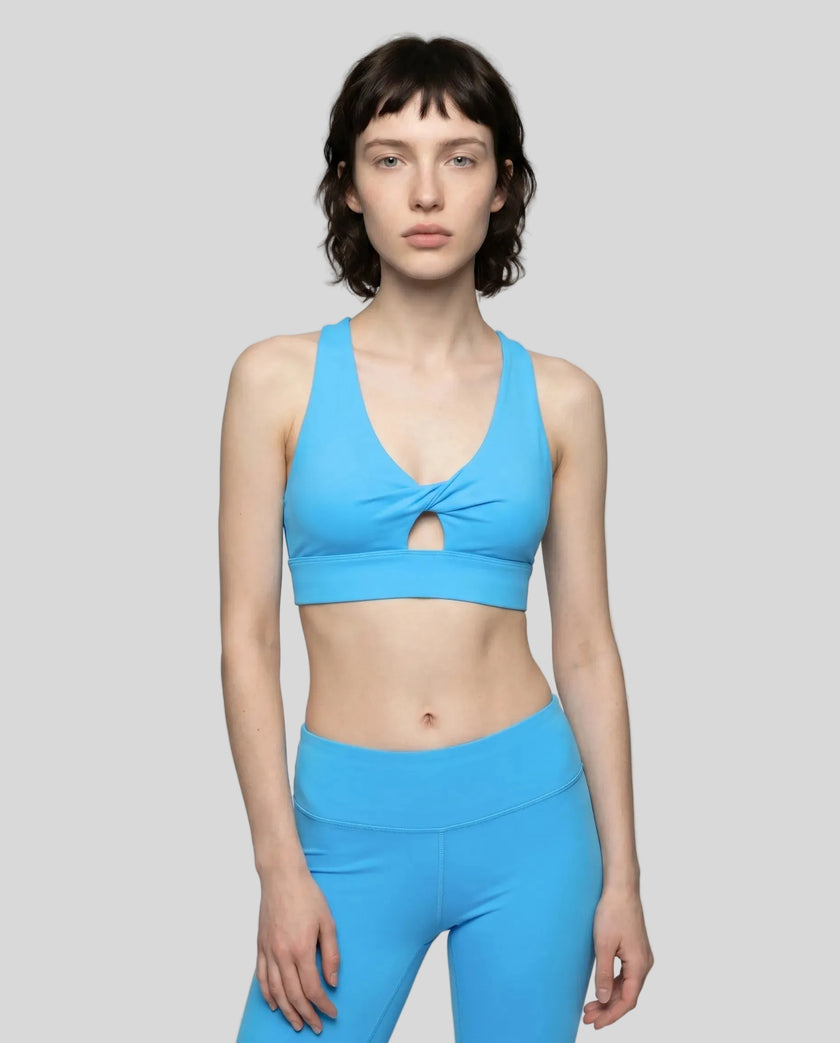Model wearing the FormLine Twist Sports Bra in blue front view