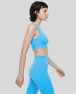 Angled side view of the FormLine Twist Sports Bra paired with activewear bottoms