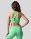 Back view of the FormLine Twist Sports Bra in green, highlighting the cross-back design