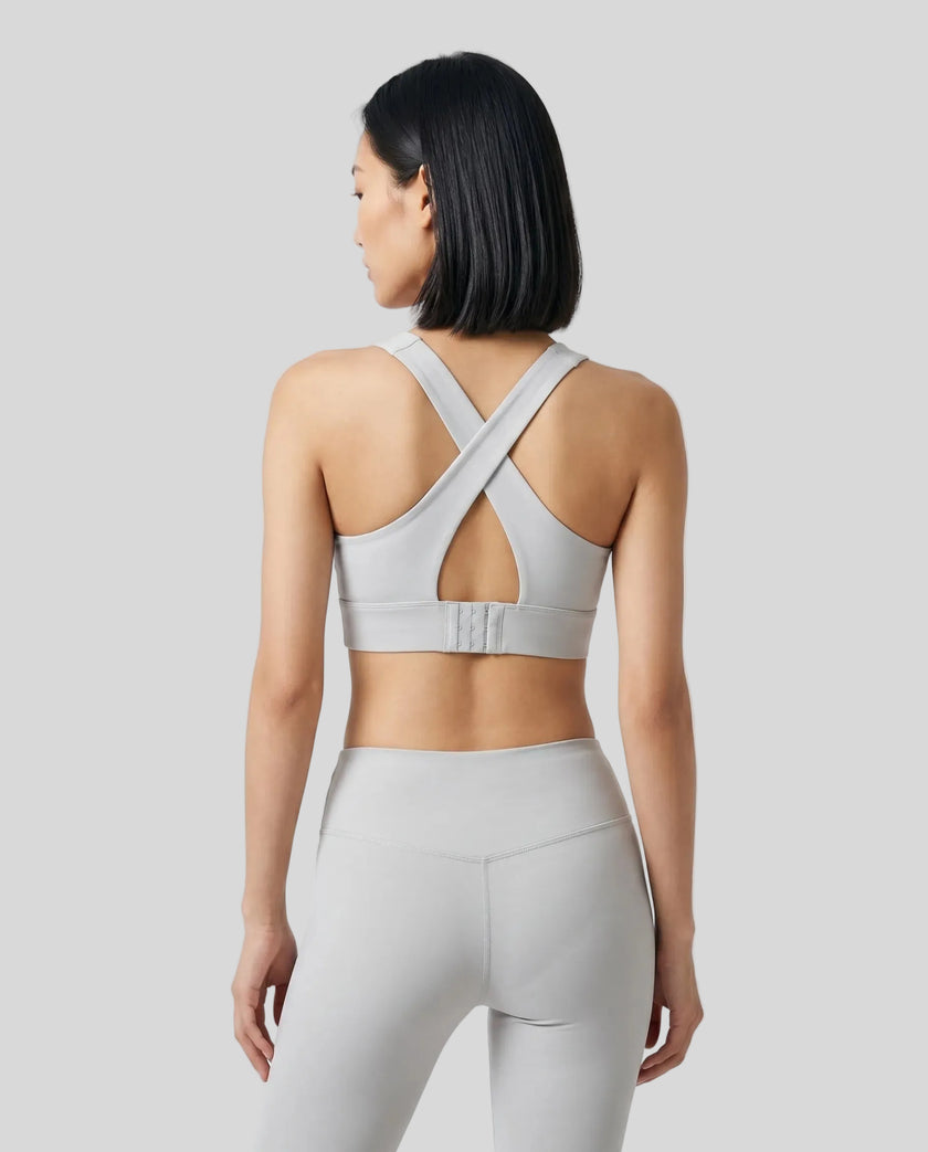 Back view of the FormLine Twist Sports Bra in light gray, highlighting the cross-back design
