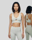Model wearing the FormLine Twist Sports Bra in light gray front view