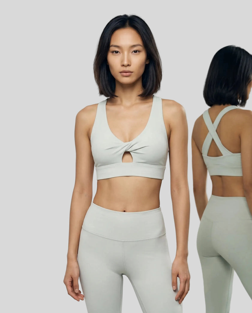 Model wearing the FormLine Twist Sports Bra in light gray front view